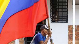 Apoiador da oposição carrega uma bandeira venezuelana durante uma manifestação em apoio à líder oposicionista María Corina Machado e pela realização de eleições livres, em Tocuyito, Venezuela, em 10 de outubro de 2026.