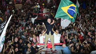 O presidente Luiz Inácio Lula da Silva, candidato do PT à reeleição, acena com uma bandeira brasileira para apoiadores durante comício de campanha em Belo Horizonte, em 21 de outubro de 2026, às vésperas do segundo turno das eleições presidenciais.