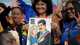 Simpatizante com cartaz com os desenhos de Nicolás Maduro e Cilia Flores