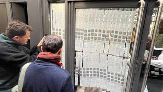 Eleitores acompanham divulgação dos boletins das urnas do segundo turno que foram exibidas no local de votação em Paris neste domingo, 25 de outubro de 2026.