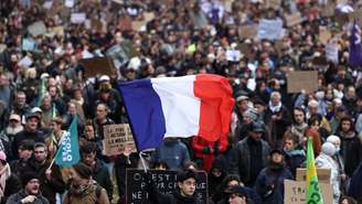 Um manifestante segura uma bandeira francesa durante uma manifestação autorizada, organizada por sindicatos em Paris, como parte dos protestos nacionais convocados pelo movimento dos "coletes amarelos", com a participação de estudantes do ensino médio e universitários franceses, contra o custo de vida e o aumento dos preços dos combustíveis, na França, em 24 de outubro de 2026.