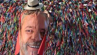 Uma mulher usa uma bandeira com a imagem do presidente Luiz Inácio Lula da Silva em frente à Igreja do Senhor do Bonfim, em Salvador, no Brasil, em 25 de outubro de 2026, durante o segundo turno das eleições presidenciais.