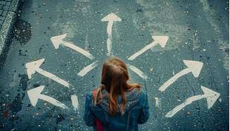 Choosing future profession. Girl standing in front of drawn signs on asphalt, top view. Arrows pointing in different directions as diversity of opportunities