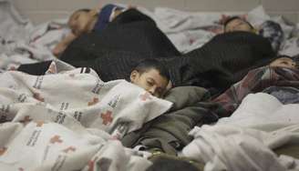 Imigrantes retidos dormem em uma instalação da Agência de Fiscalização de Alfândega e Proteção de Fronteiras dos EUA, em Brownsville, no Texas, em 18 de junho. 18/06/2014