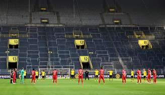 Jogadores de Borussia Dortmund e Bayern Munich fazem minuto de silêncio em homenagem às vítimas da Covid-19 antes do início de jogo sem público no estádio
26/05/2020
Federico Gambarini/Pool via REUTERS