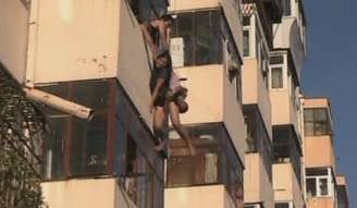 Imagem de vídeo mostra a mulher sendo resgatada em prédio na localidade de Harbin, no sábado
