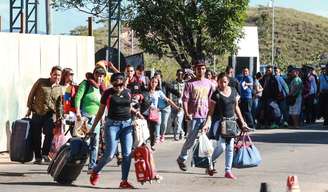  Imigrantes venezuelanos cruzam a pé a fronteira entre Venezuela e Brasil