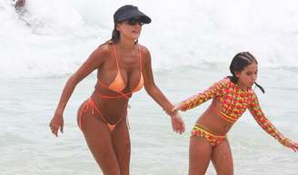 Deborah Seko chose a neon orange bikini to enjoy the beach with her daughter, Maria Flor.