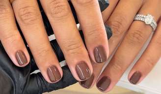 Confira agora mesmo 6 opções de unhas elegantes para apostar no Outono 2026; modelo usa cor marrom chocolate nas mãos.