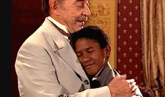 Tiziu (André Luiz Miranda) fica emocionado ao ser matriculado em escola por Francesco (Raul Cortez) na novela 'Terra Nostra'.