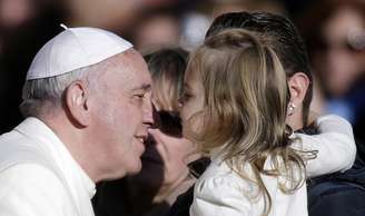 Papa interage com criança antes de sua audiência semanal na Praça São Pedro nesta quarta