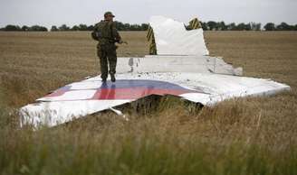 Separatista armado pró-Rússia sobre destroço do avião da Malaysia.