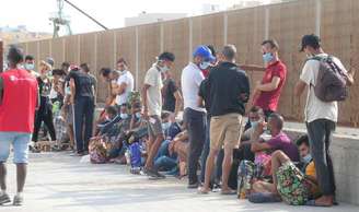 Migrantes em Lampedusa aguardam transferência para navio de quarentena