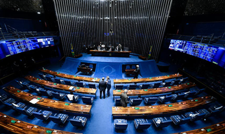 Foto do Plenário do senado, com tapete azul e cadeiras em madeira