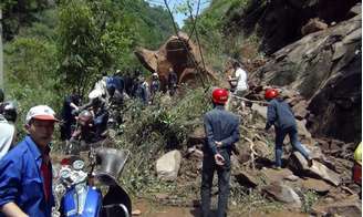 Socorristas tentam remover pedras bloqueando estrada depois de forte terremoto no condado de Lushan, na China.