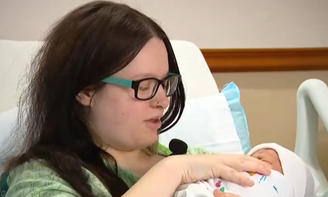 Mulher com o filho no hospital após dar à luz no trabalho