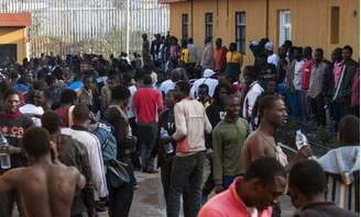 <p>Imigrantes se reúnem no pátio de um centro de detenção temporária de imigrantes depois de cruzar a fronteira do Marrocos</p>