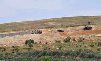 <p>Placas de concreto são colocadas na fronteira turco-síria durante a construção de um muro em Reyhanli, na província de Hatay, ao sul da Turquia, em 28 de abril</p>