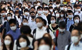 Passageiros usando máscaras de proteção caminham em direção à estação de Shinagawa, em Tóquio
28/07/2021 REUTERS/Kim Kyung-Hoon