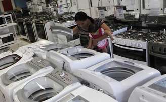 <p>Uma mulher e sua filha olham uma máquina de lavar em uma loja da Casas Bahia, em São Paulo; Índice de Confiança do Consumidor (ICC) atingiu em outubro menor nível desde abril de 2009</p>