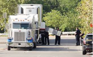 Oficiais forenses de polícia trabalham no caminhão onde oito pessoas foram encontradas mortas em San Antonio