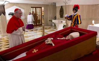 Papa Francisco em um caixão simples de madeira com forro vermelho.