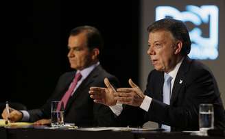 Óscar Zuluaga faz anotações enquanto escuta o presidente Juan Manuel Santos durante debate