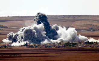 Fumaça se espalha em uma vila nos arredores da cidade síria de Kobani, perto da fronteira com a Turquia. 15/10/2014.