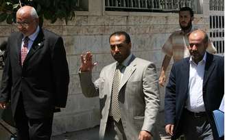 <p>Ayman Taha (ao centro) chega a um encontro com autoridades do Fatah na Faixa de Gaza, em 14 de junho de 2009</p>