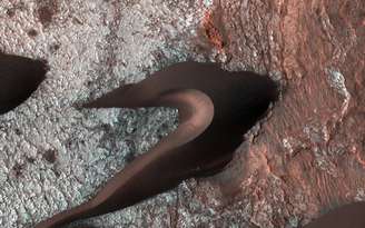 Imagem da sonda Reconnaissance Orbiter mostra a movimentação das dunas de areia no solo de Marte. Segundo a Nasa, a foto sugere que a superfície em volta das dunas já foi molhada e rachou quando secou.  