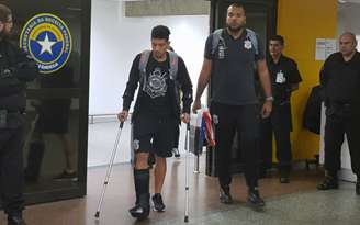 Na quinta-feira, Douglas voltou ao Brasil com muletas e bota para imobilizar o pé direito (Foto: Guilherme Amaro)