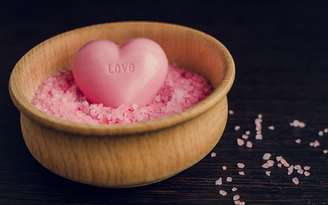 Sabonete em forma de coração dentro de um recipiente com pedras rosas