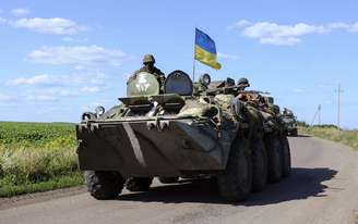 Em imagem do dia 3 de julho, soldados ucranianos conduzem um tanque militar com uma bandeira da Ucrânia em um posto de controle perto de Slaviansk