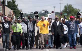 <p>Manifestantes marcham em protesto contra a morte de Micahel Brown no centro de Ferguson, Missouri, em 11 de agosto</p>