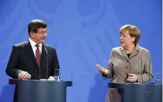 O primeiro-ministro turco, Ahmet Davutoglu (esquerdo), e a chanceler alemã, Angela Merkel, concedem entrevista coletiva em Berlim, na Alemanha, nesta segunda-feira. 12/01/2015