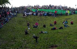 <p>Mulheres participam da tradicional corrida do queijo em Gloucestershire, oeste da Inglaterra</p>