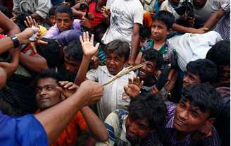 Voluntário tenta controlar refugiados rohingyas em Cox's Bazar, Bangladesh 
  20/9/2017    REUTERS/Danish Siddiqui