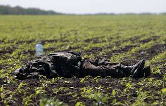 <p>Um corpo coberto com um uniforme pôde ser fotografado em um campo perto da vila de Blahodatne, no leste da Ucrânia, nesta quinta-feira. Pelos menos 8 membros das forças de segurança ucranianas morreram</p>