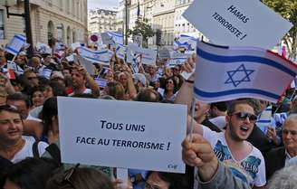 <p>Manifestantes seguram bandeiras e cartazes que dizem "Todos Unidos Contra o Terrorismo" e "Hamas terrorista", durante aprotesto pró-Israel perto da Embaixada de Israel em Paris, nesta quinta-feira, 31 de julho</p>
