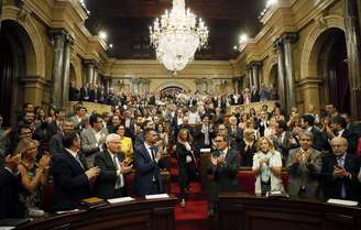 <p>Membros do parlamento catalão aplaudem em Barcelona a aprovação da lei que autoriza a realização de um referendo sobre a independência da região</p>
