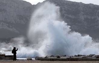 Homem fotografa ondas em Marselha após passagem da tempestade pela França