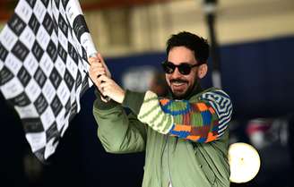 Mike Shinoda, músico da banda Linkin Park, agita a bandeira quadriculada do GP de Interlagos