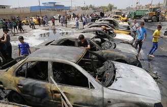 Pessoas se reúnem em local de ataque com carros-bomba no distrito de Sadr City em Bagdá; série de explosões em toda a capital iraquiana mataram 24 pessoas 