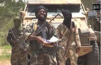 <p>Trecho do vídeo, obtido em 13 de julho, divulgado pelo grupo extremista islâmico nigeriano Boko Haram, mostra o líder do grupo, Abubakar Shekau (ao centro) manifestando apoio ao sunita Estado Islâmico (EI), do Iraque</p>