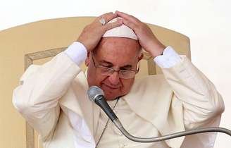 <p>O papa Francisco ajusta seu solidéu durante audiência semanal na Praça São Pedro, no Vaticano, na quarta-feira</p>