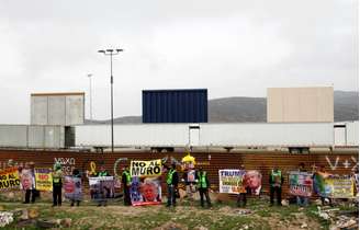 Pessoas seguram cartazes em protesto contra muro proposto por Trump em Tijuana
 13/3/2018     REUTERS/Jorge Duenes