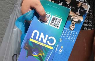 Candidato segura panfleto do CNU 2025 após realização do primeiro dia de provas em 5 de outubro.
