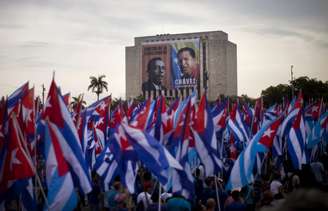 Cubanos participam de ato nas proximidades de prédio coberto com imagens de Chávez e do líder sindical Lazaro Peña