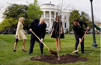 Os presidentes dos EUA, Donald Trump, e da França, Emmanuel Macron, plantam muda de carvalho dada a Trump por Macron. 23/04/2018. REUTERS/Joshua Roberts