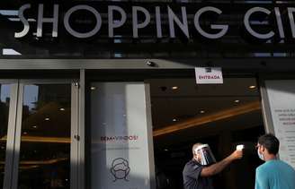 Funcionário checa temperatura de cliente na entrada de shopping center em São Paulo. 11/6/2020. REUTERS/Amanda Perobelli